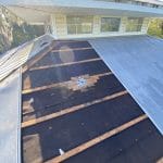 Robertson Roofing team repairing a metal roof puncture in Fort Myers, ensuring a durable and watertight solution.