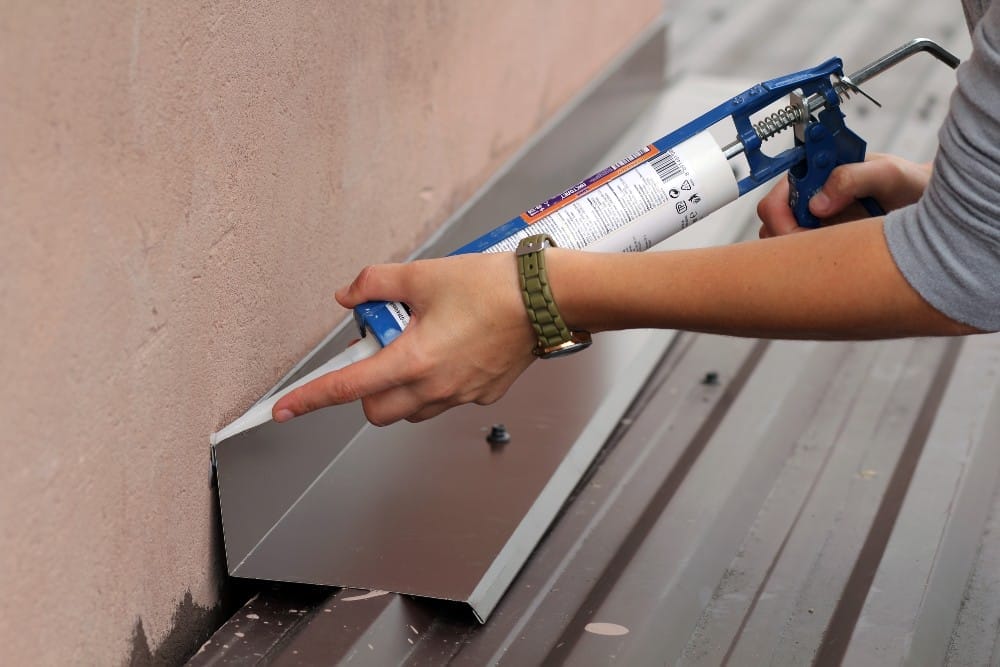 Applying silicone sealants for metal roof repair in Fort Myers, FL.